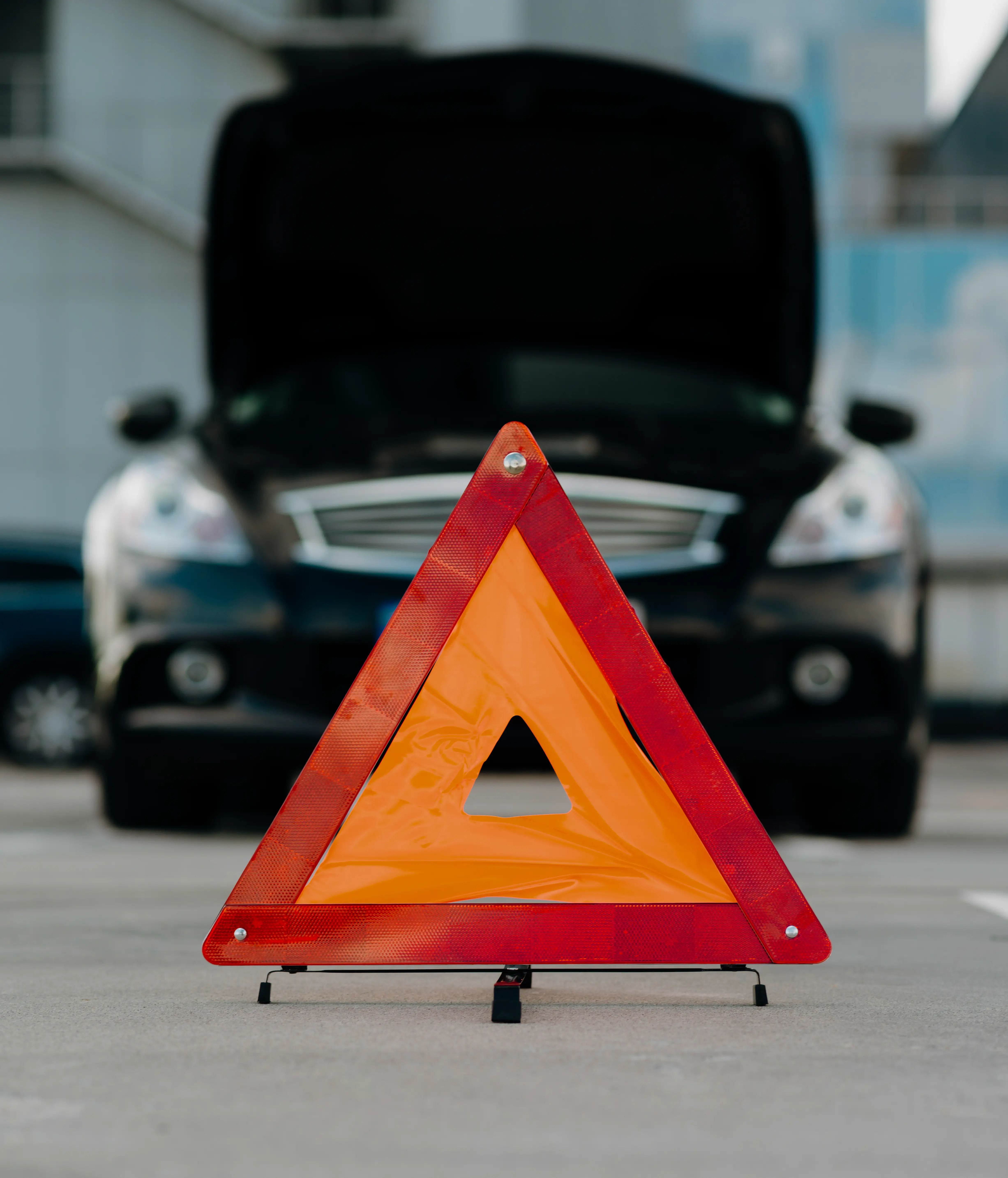Аварійний знак біля автомобіля — страхування оренди авто REIZ